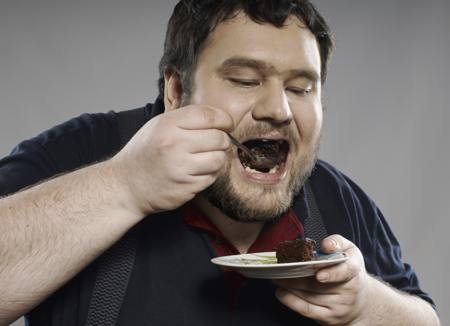 Fat guy eating chocolate cake